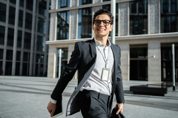 A successful happy businessman going to the office in the afternoon in a business suit with a...