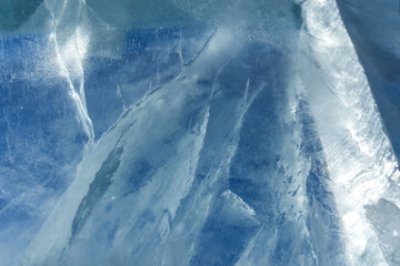 The pattern and texture of blue ice on the surface of a frozen lake. Abstract ice background