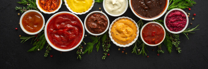 Different types of sauces in bowls with seasonings banner, rosemary and dill, thyme and and peppercorns, top view, copy space