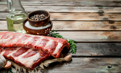 Raw ribs with spices and rosemary .
