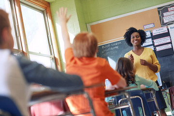 Education, teacher and children in classroom with question in academy lesson, learning and...