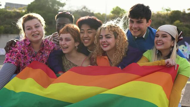 Group of happy young people having fun together during LGBT pride parade
