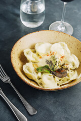 Boiled homemade dumplings with sour cream