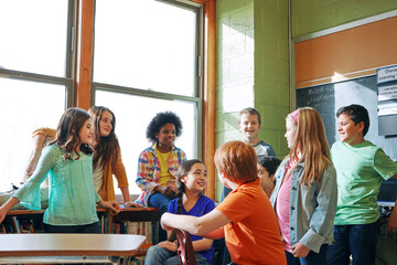 School, children and students talking in a classroom to learn, and study for knowledge and...