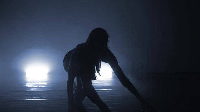 Erotic young woman dancing single in club, neon light, lots of smoke