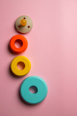 The composition of wooden light blue, yellow, orange from bigger to smaller rings for baby...