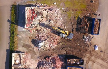 Demolition of a residential building with an excavator, construction work, urban development,...