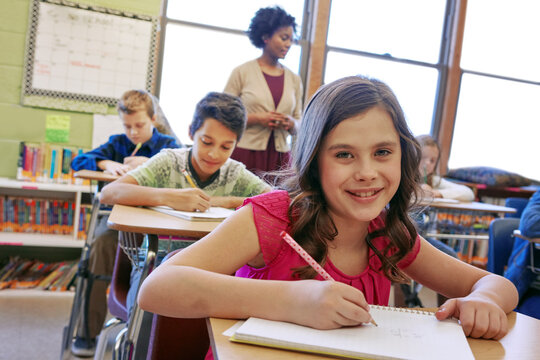 Learning, Happy And Girl Portrait In Classroom With Notebook For Lesson Notes And Knowledge. School Kids, Education And Development Of Middle School Children Writing In Books With Focus.