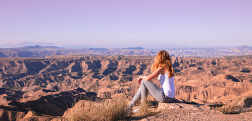 Woman sitting and looking at sunset Gorafe desert in Spain © M.studio