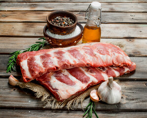 Raw ribs with spices and rosemary .