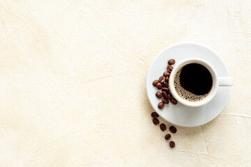 White cup of hot black espresso with coffee beans