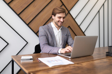 Fototapeta premium pretty successful businessman working in the office on a laptop