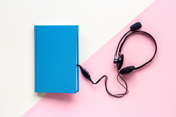 Audiobook or podcast concept with book and headphones nearby