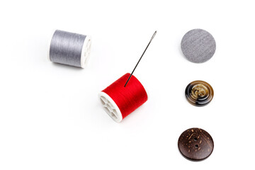 group of sewing spools and two needles isolated on white background with real shadows