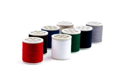 group of sewing spools and two needles isolated on white background with real shadows