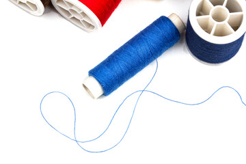 group of sewing spools and two needles isolated on white background with real shadows