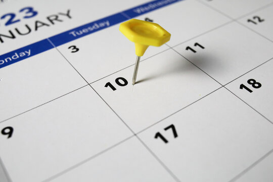 Embroidered yellow pins on a calendar on the 10 th  with selective focus