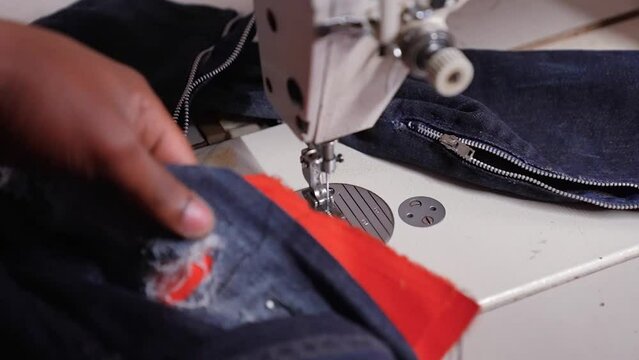 Close-up of local fashion designer in Alexandra Township in South Africa busy sewing