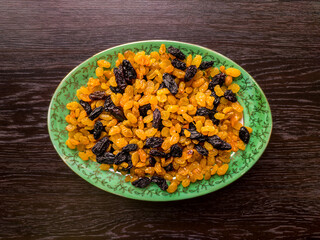 plate with raisins on a dark wooden background