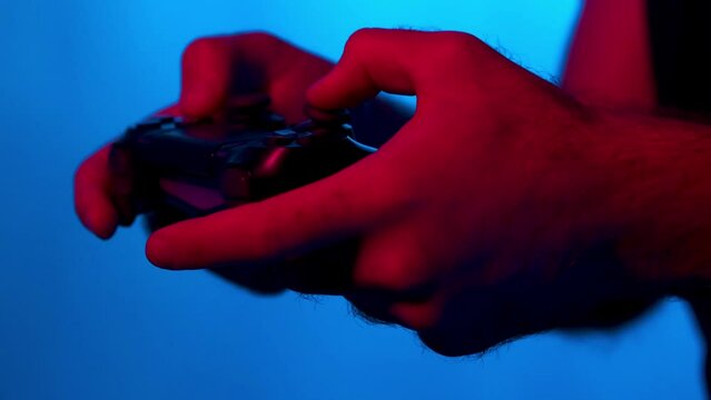 Close-up hands  showing a gamer using the joystick while playing an pnline shooter video game. 