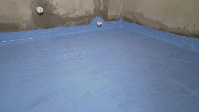 Blue floor waterproofing in the bathroom. Blue floor in the bathroom, waterproofing. The bathroom floor was painted blue. The floor is covered with blue waterproofing. 