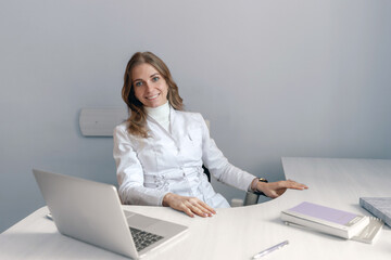 Young female doctor talking to patient online from medical office.