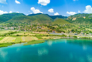Fields planted with grain crops near Montenegrin villages on the coast of the Adriatic Sea against the backdrop of the Balkan Mountains and sky