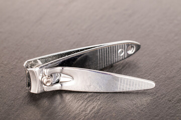 Metal nail scissors on slate stone, macro.