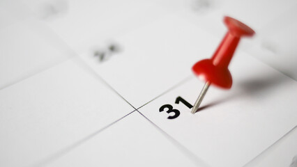Embroidered red pins on a calendar on the 31 st  with selective focus