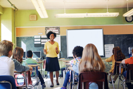 Black Woman, Teacher And Classroom With Students For Education, Learning Support And Knowledge Development. African Female, Preschool Classroom And Academic Discussion Or Teaching Young Children