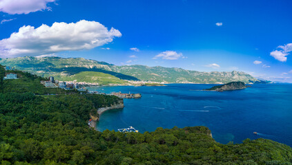 Fototapeta na wymiar Panorama of bird's eye view of towns of Budva and Becici with hotels and beaches near Adriatic Sea against the backdrop of the Montenegrin Mountains