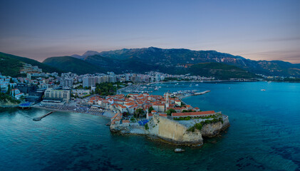 Panorama of port with boats for excursions on the Adriatic Sea near the island of St. Stevan in the evening city of Budva