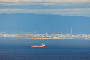 Cargo Ship Sails to Port in Osaka Bay by Rinku Gate Tower on Sunny Day