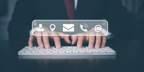 Communication and Contact us or Customer support hotline people connect. Businessman Hand using a laptop and touching on virtual screen contact icons, email and address, live chat with internet wifi.