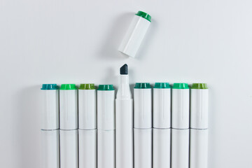 Colored green markers on a white background. Markers for drawing.