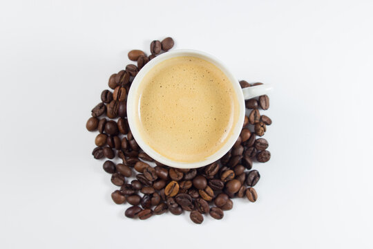 Cup of espresso coffee with coffee beans on white background © Ruzanna