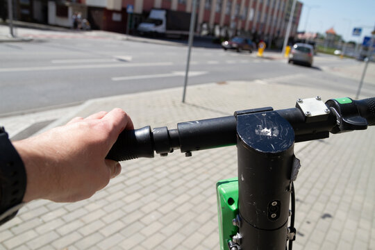 Man using electric scooter to rent via app. Scooter sharing system, renting modern vehicle with mobile phone. Riding point of view in first person.