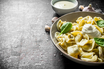 Dumplings on a plate with sour cream and spinach.