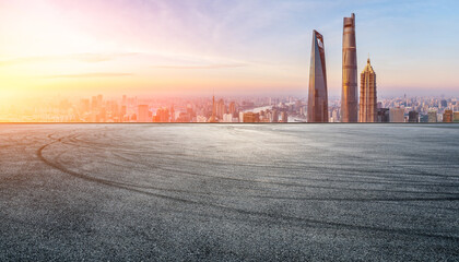 Asphalt road and city skyline with modern buildings in Shanghai at sunrise, China.
