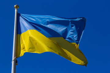 National flag of Ukraine against blue sky, The wind blows out