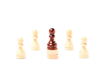 White chess pawns surrounding a black pawn on white background