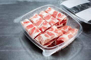 A view of a Kurobuta pork neck meat in a plastic container.