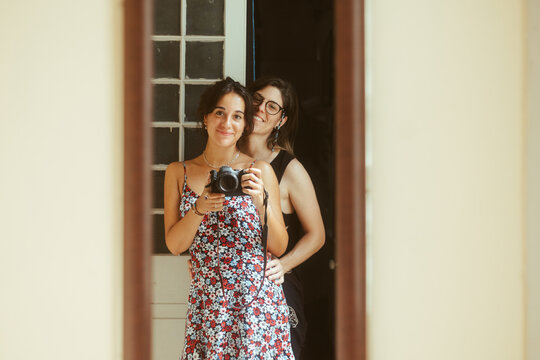 Young couple women taking photo on camera in mirror