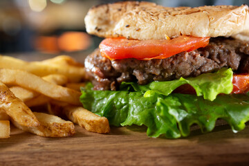 A closeup view of a hamburger, with a side of french fries.