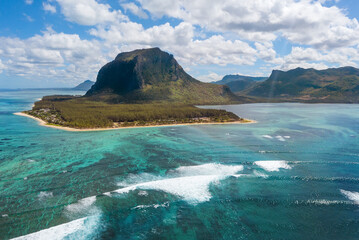 Turquoise clean lagoons protected by coral reefs of Le Morne peninsula with basalt mount on Mauritius island. Also a wonderful kiteboarding and windsurfing spot. Exotic traveling aerial photo concept.