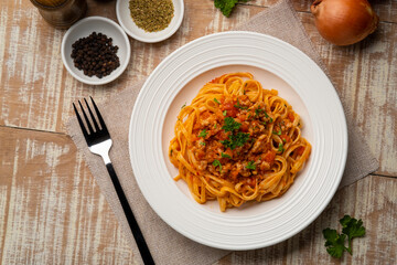 Spaghetti with minced pork in tomato sauce, pasta with a meat based bolognese tomatoes,served on white plate, linguine pasta.Top view