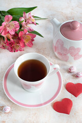 Fototapeta na wymiar cup with tea, teapot and rose flowers on the table