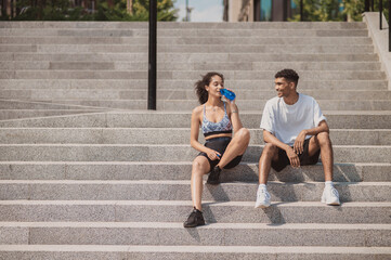 Sportspeople sitting on the concrete steps after the outdoor workout