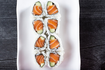 A top down view of a salmon and cucumber roll.