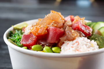 A closeup view of a combo poke bowl, featuring salmon, yellowtail and ahi tuna. © DAVID